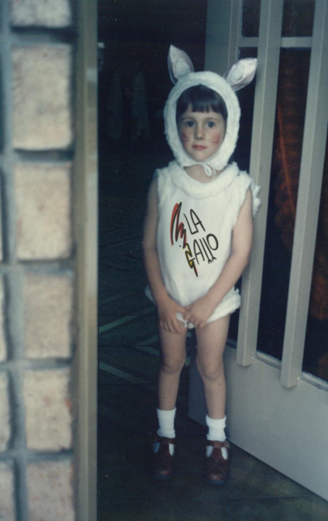 Fotografía de infancia de Carolina Gallo, fundadora de LA GALLO ART, con disfraz y logo de la marca, símbolo del humor y la autenticidad que inspiran su arte.