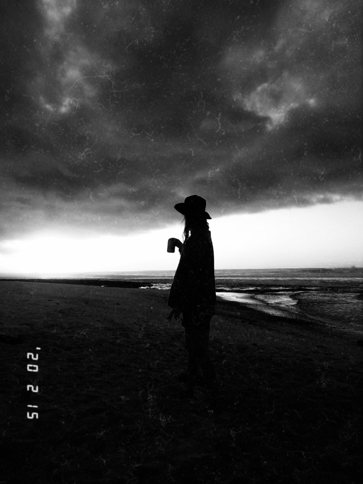 Silueta de Carolina Gallo mirando al horizonte en la playa. Imagen poética que refleja la libertad y la introspección detrás de LA GALLO ART.