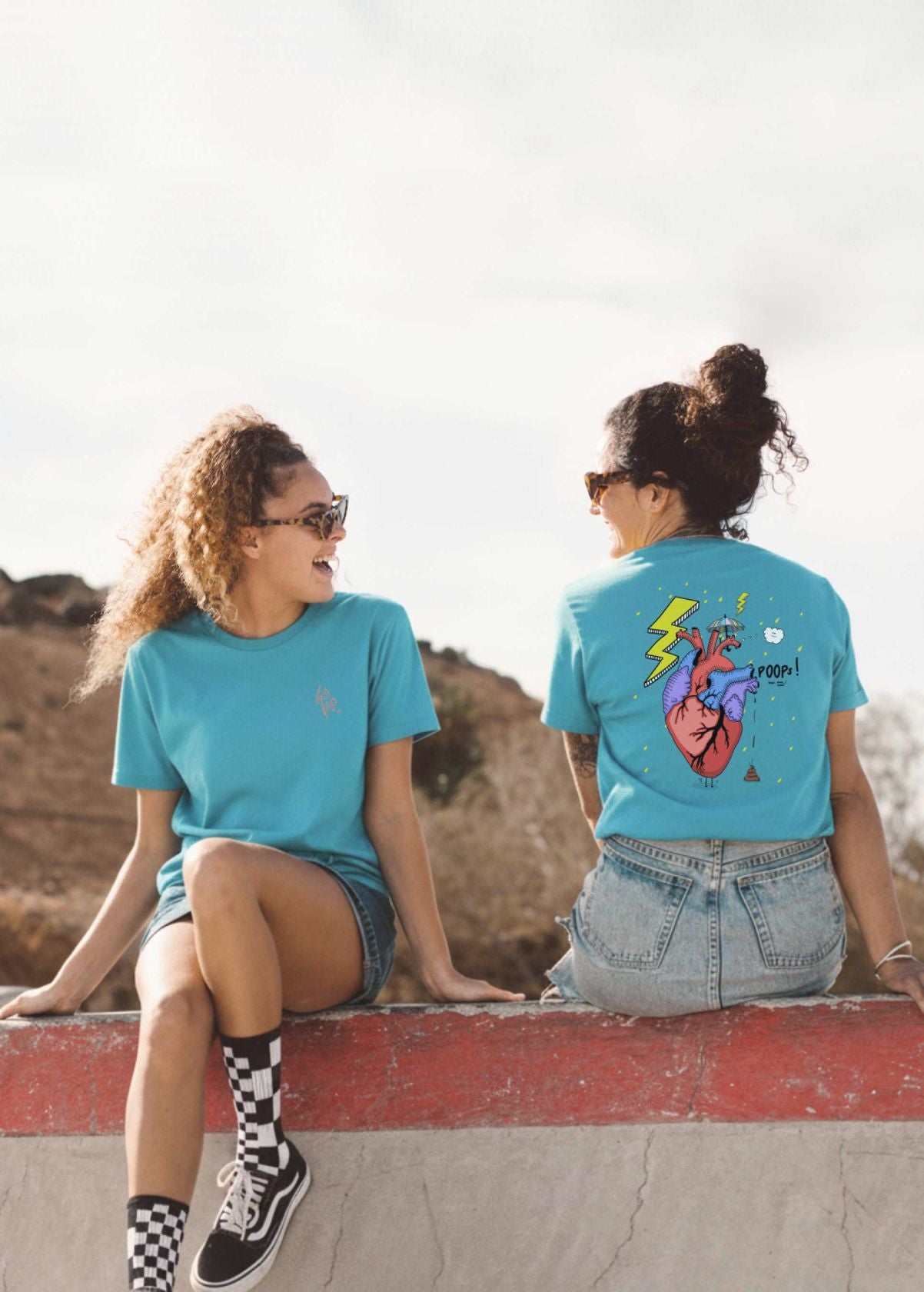 Mujeres con camiseta unisex “Corazón” color Aqua Blue, vista de frente. Ilustración full color creada por Carolina Gallo – LA GALLO ART.