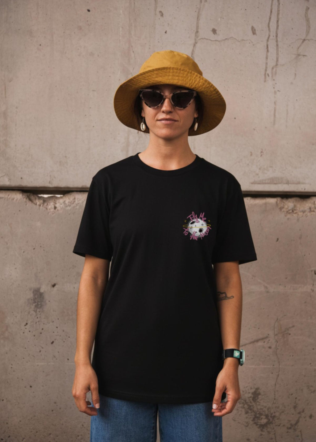 Mujer con camiseta unisex “En la luna de Valencia” negra, vista de frente. Diseño original de Carolina Gallo – LA GALLO ART.