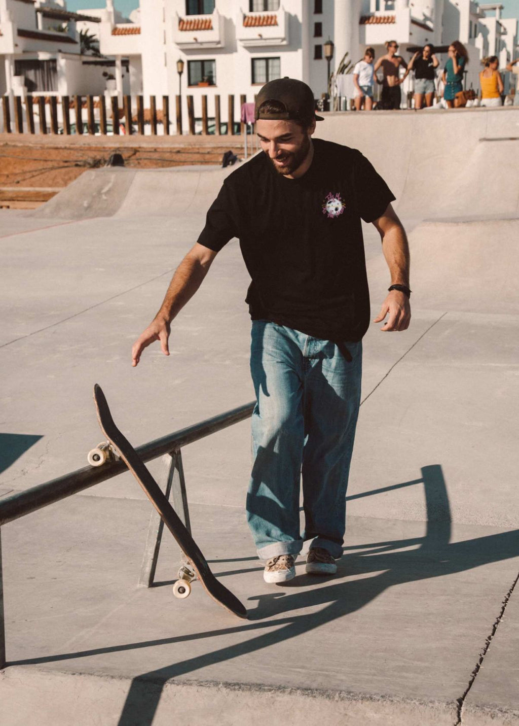 Skater con camiseta unisex “En la luna de Valencia” negra, vista de frente. Ilustración de LA GALLO ART en arte digital independiente.