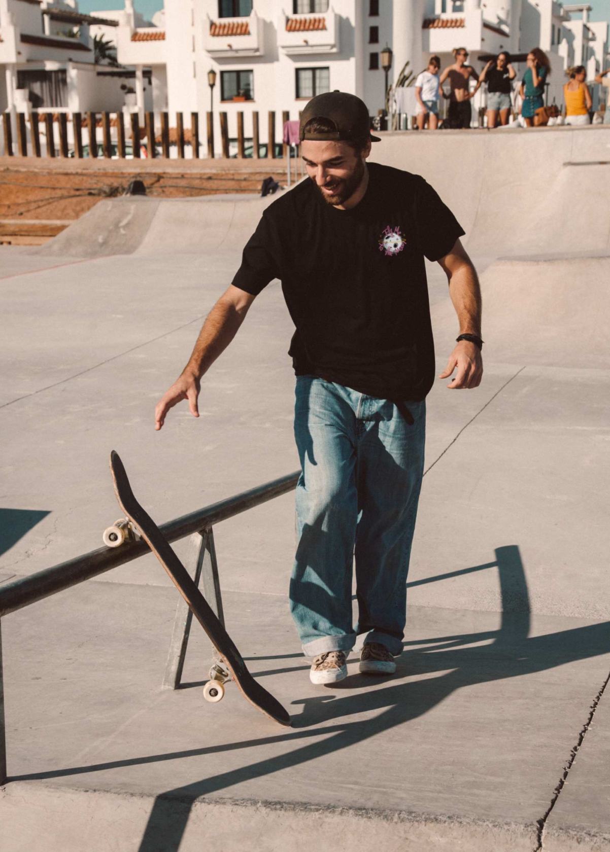 Skater con camiseta unisex “En la luna de Valencia” negra, vista de frente. Ilustración de LA GALLO ART en arte digital independiente.