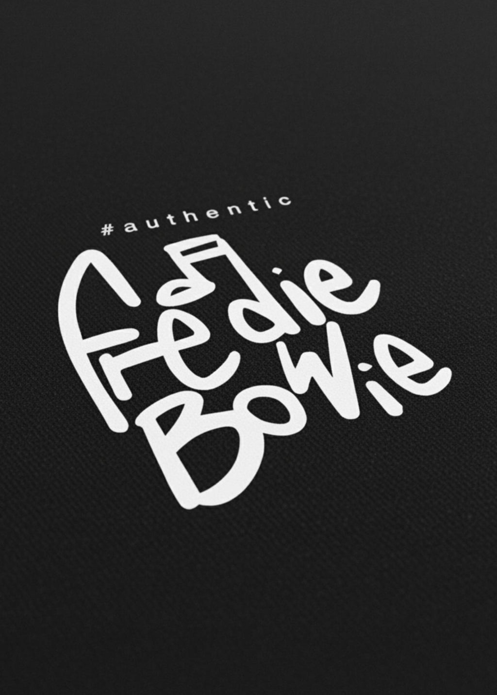 Detalle frontal del logo #authentic en camiseta unisex “Freddie Bowie” negra. Impresión nítida de alta calidad.