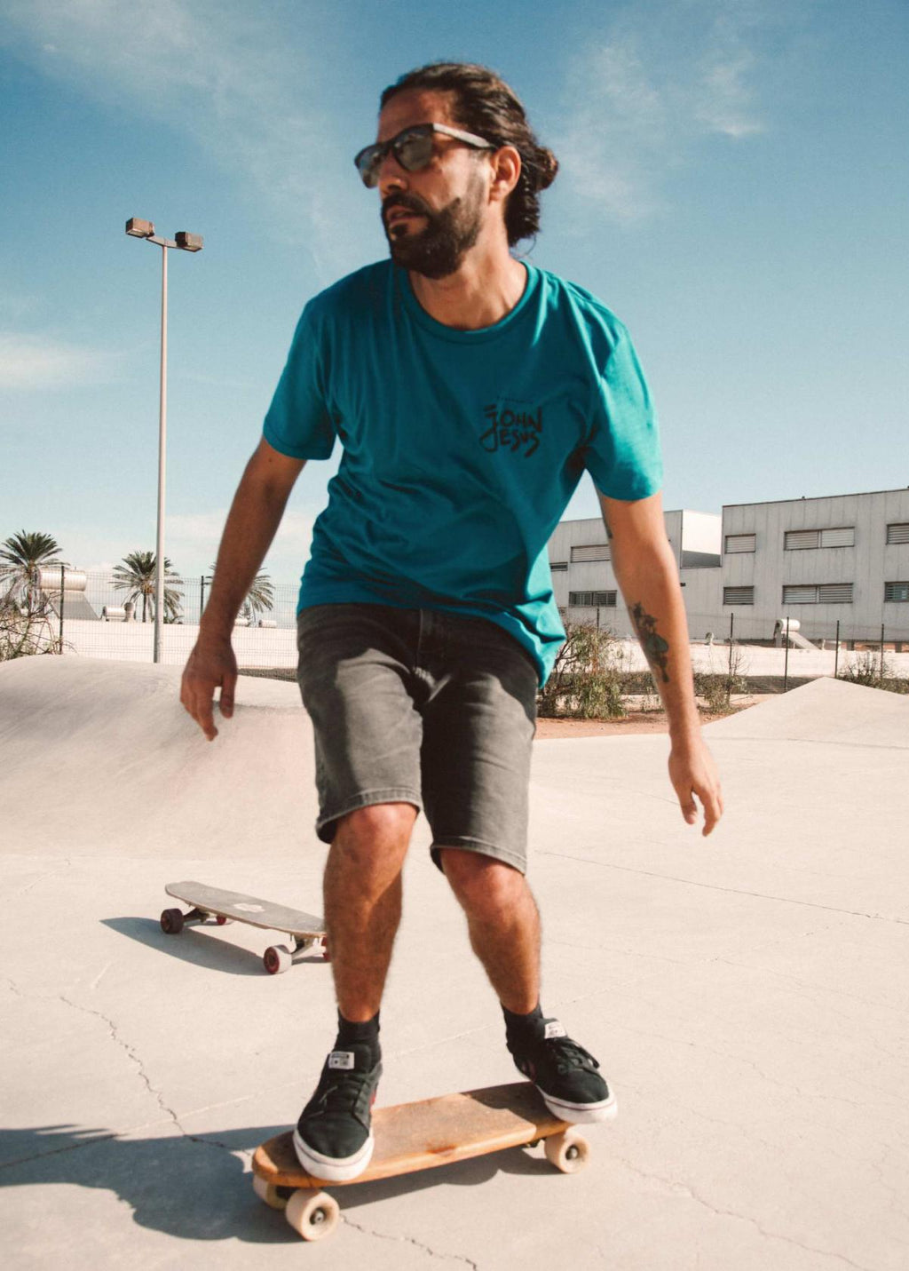 Hombre con camiseta unisex “John Jesus” color Ocean Depth, vista de frente. Arte digital independiente creado por Carolina Gallo – LA GALLO ART.