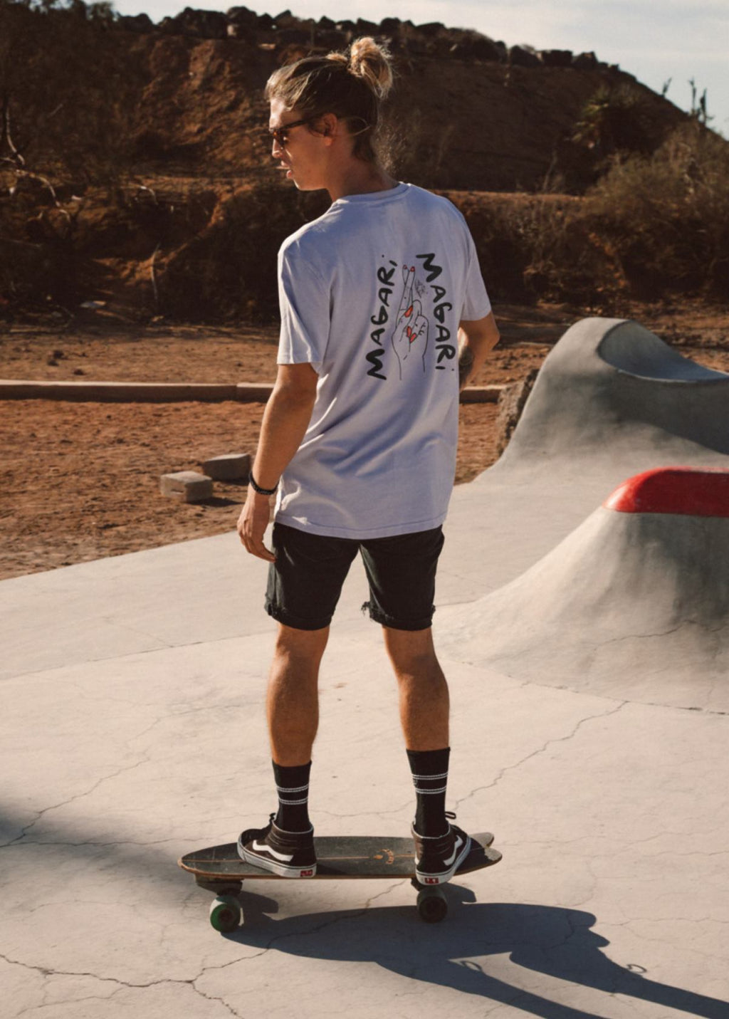 Hombre con camiseta unisex “Magari” color Lavender, vista de espalda. Diseño artístico impreso en algodón ecológico.