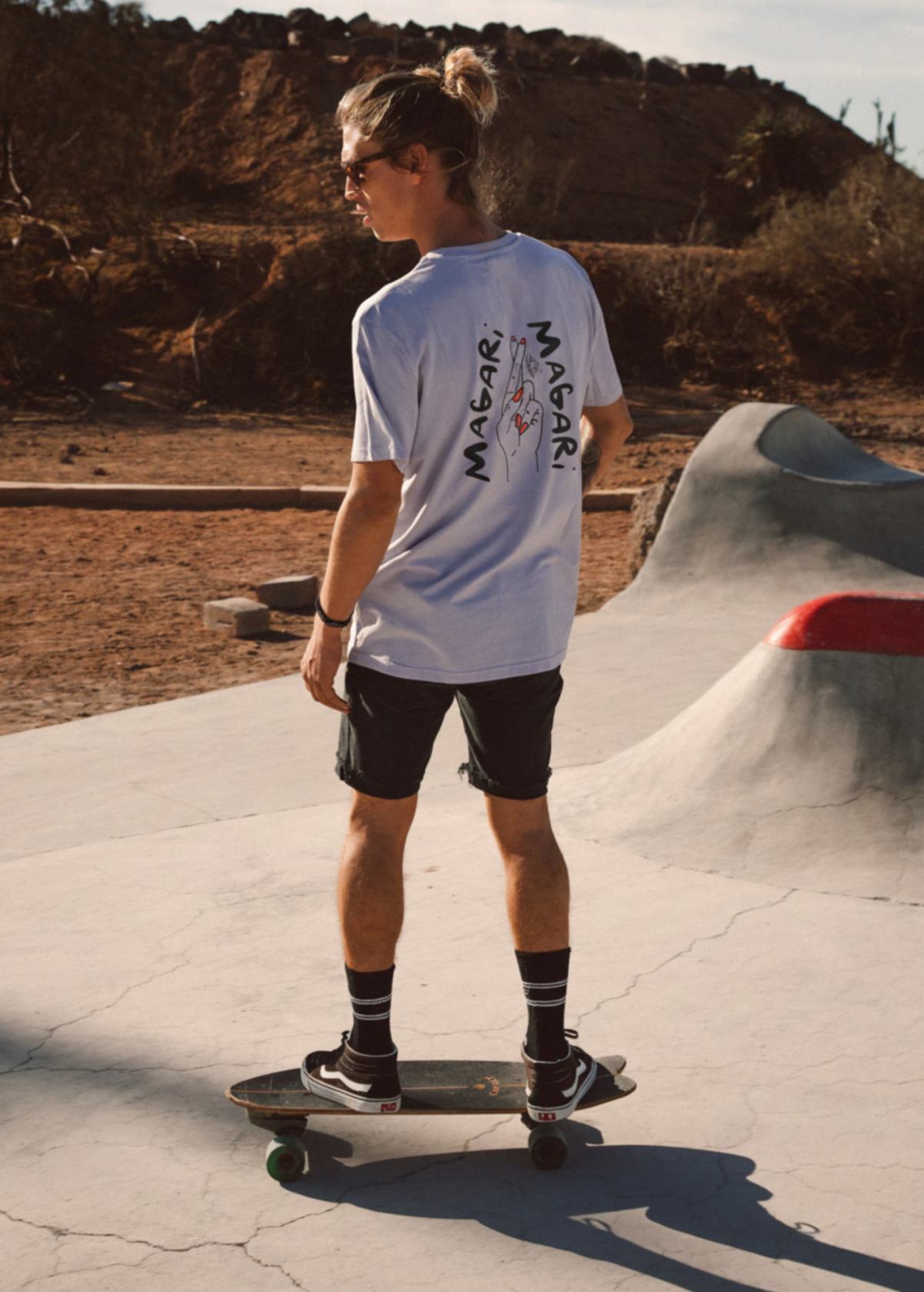 Hombre con camiseta unisex “Magari” color Lavender, vista de espalda. Diseño artístico impreso en algodón ecológico.